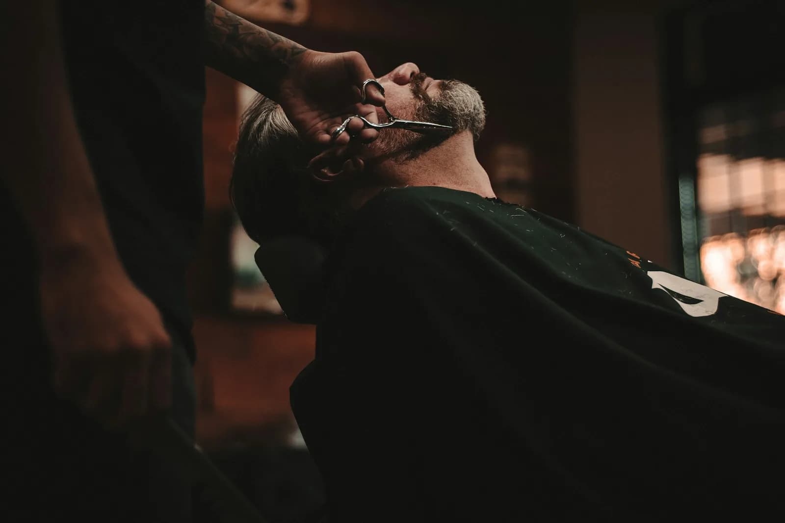 Barber carefully trimming a client’s beard